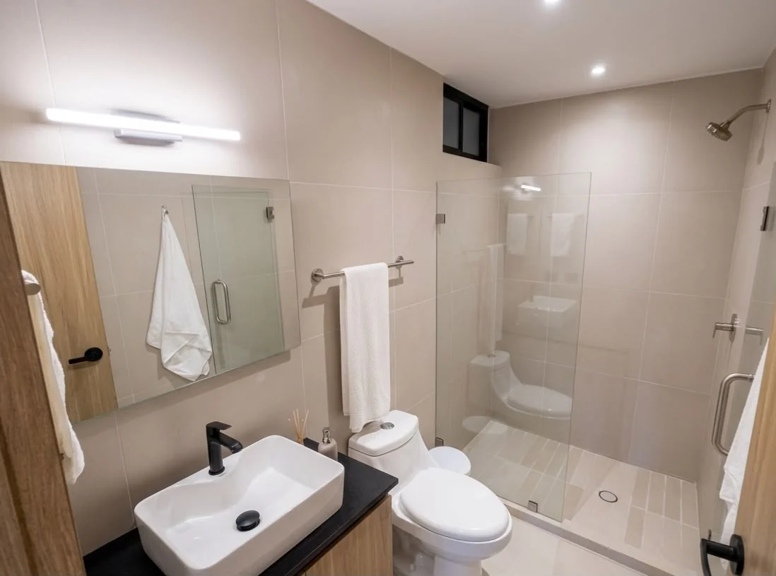 Baño del departamento muestra con regadera de cristal templado